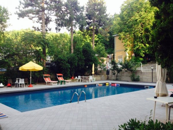 Una piscina circondata da sedie a sdraio e ombrelloni gialli.