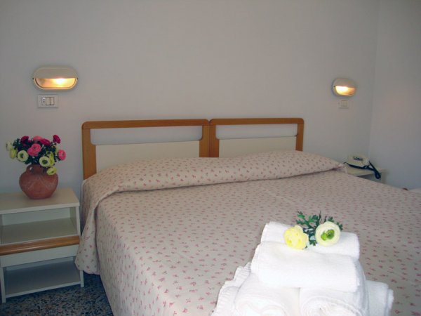 Letto matrimoniale con copriletto floreale.