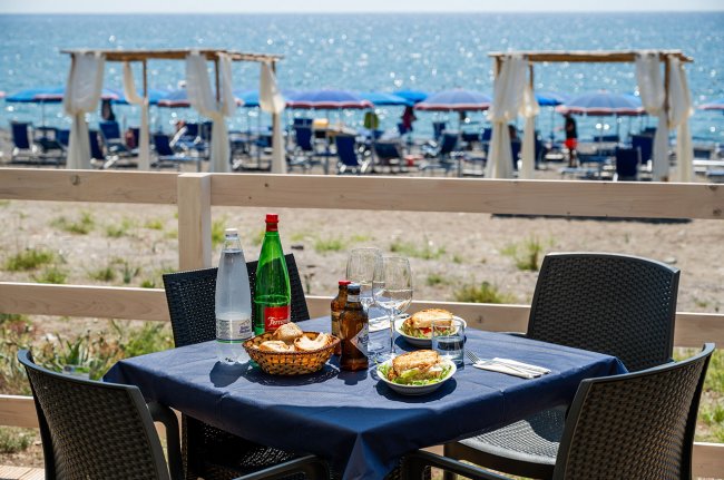 Tavolo apparecchiato con cibo vista mare.