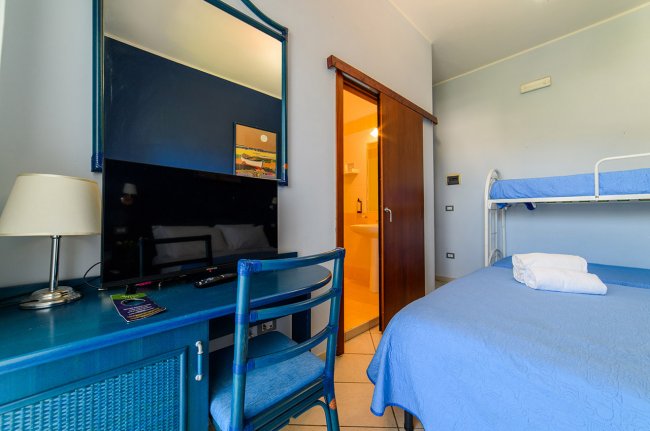 Stanza con letto matrimoniale e scrivania blu.