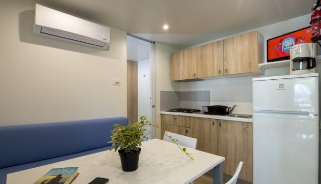 Cucina moderna con tavolo bianco e pianta.