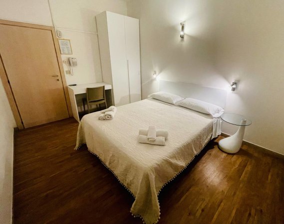 Camera da letto con letto matrimoniale e scrivania.