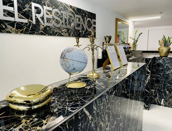 Reception con banco in marmo scuro.