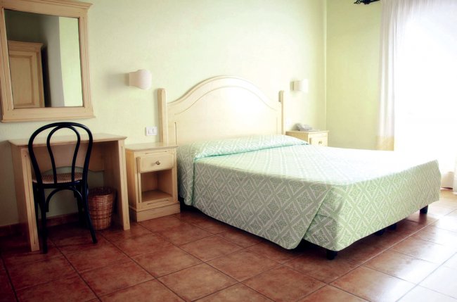 Camera da letto con letto matrimoniale e scrivania.