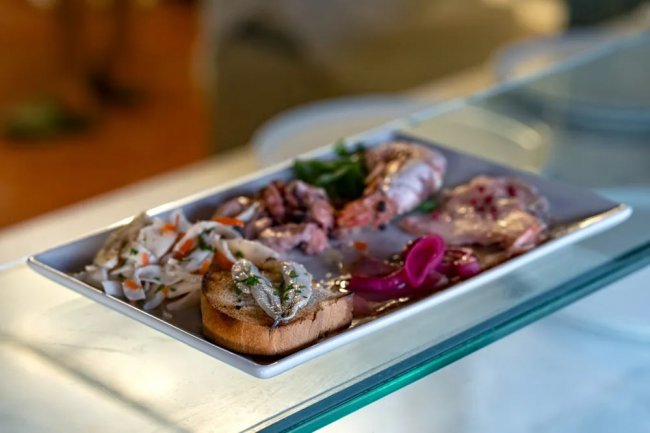 Piatto di antipasti misti su un piatto bianco.