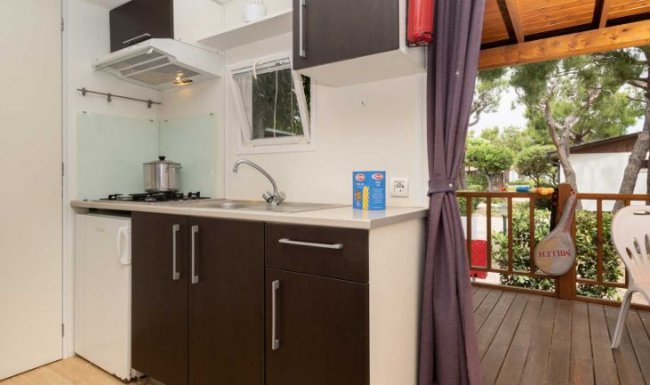 Cucina moderna con armadietti scuri e una finestra.