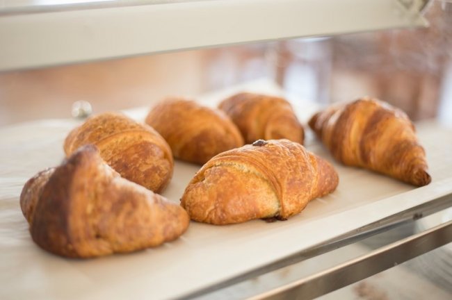 Sei croissant su un vassoio bianco.