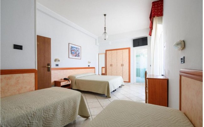 Camera d'albergo con tre letti singoli.