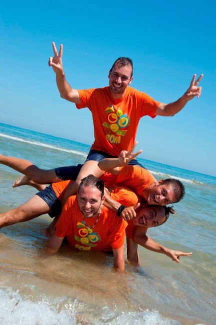 Persone sorridenti fanno una piramide in acqua.