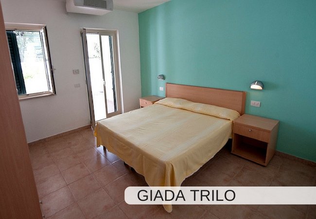 Camera con letto matrimoniale, parete verde.