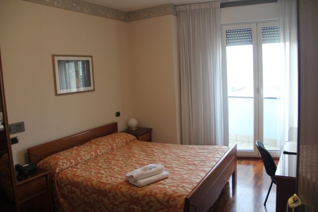 Camera da letto con letto matrimoniale e porta finestra.
