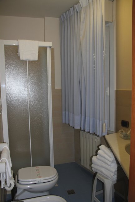 Bagno con doccia e asciugamani.