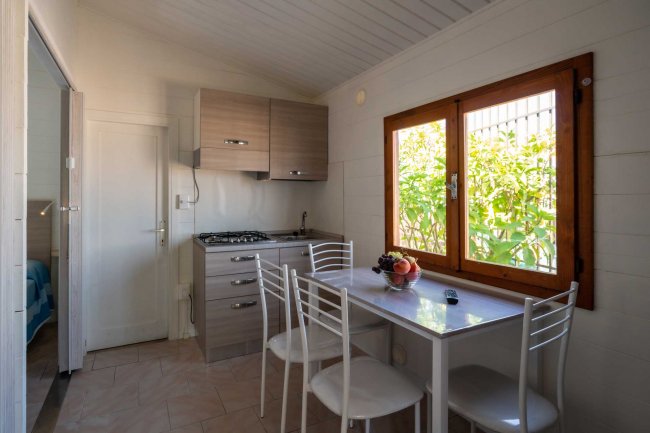 Angolo cottura con finestra e tavolo bianco.