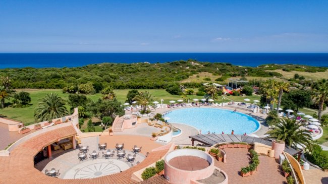 Piscina circolare con vista sull'oceano e terrazza.